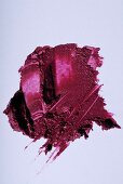 Dunkelrosa Lippenstift verstrichen auf weißem Untergrund