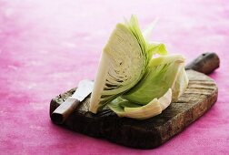 A quartered of a white cabbage on a chopping board