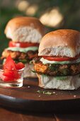 Two Indian veggie burgers on a wooden board
