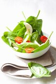 Spinach salad with goat's cheese, pears, cherry tomatoes and balsamic vinegar