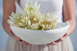 Girl holding bowl of tropical flowers