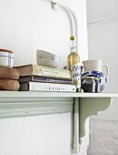 Books and cooking utensils on kitchen shelf