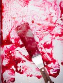 A baking tray and a palette knife smeared with plum juice