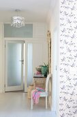 Open frosted glass door, Baroque chair and lace-patterned ceiling lamp in foyer