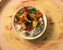 Fried pork with peppers on a bed of rice with coriander
