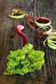 Rhubarb stalks and rhubarb peel on a wooden surface