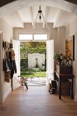 Coat rack and open double doors in hallway of renovated country house