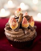 A chocolate cupcake decorated with a chocolate fondant campfire