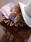 Sliced white bread with napkins and a cowboy hat on an animal hide stool