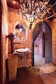 Washstand made from rustic hand pump against brick wall; arched, Medieval-style doorway