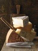A stack of various hard cheeses with a knife