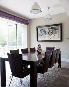 Dark wooden table and chairs on rustic stone floor next to terrace doors