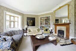 Patterned sofa and solid wooden coffee table in front of fireplace in traditional, polygonal living room