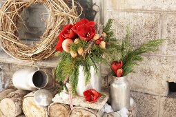 Ein winterlicher Blumenstrauß mit Amaryllis, Nüssen, Äpfeln und Thuja-Zweigen in alten Milchkannen aus Blech