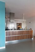 Island counter with wide wooden drawer elements in open-plan modern kitchen