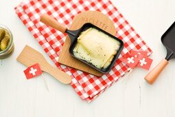 Raclette cheese in pans and black flags