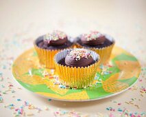 Dunkle Schokoladencupcakes mit bunten Zuckerstreuseln