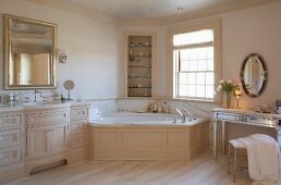 Elegant, country-house bathroom with corner bathtub and dressing table