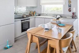 Pale wood dining area integrated into fitted kitchen