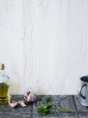 Olive oil, garlic and basil on tiled countertop