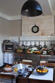 Mediterrane Küche mit modernen Edelstahlgeräten und einem gemütlich gedeckten Frühstückstisch