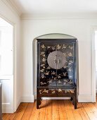 Black-lacquered Chinese wedding cabinet with gold inlays in arched niche