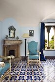 Eleganter Fliesenboden mit Ornament Muster, gepolsterte Stühle mit hellblauem Bezug vor offenem Kamin (Villa Cimbrone Hotel)