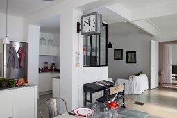 Kitchen area behind partially glazed partition in open-plan interior