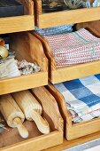 Kitchen utensils (tea towels, rolling pins) in wooden drawers