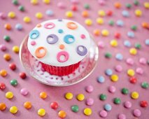 A cupcake decorated with colourful fondant icing