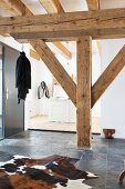 Rustic wooden beams and cowhide rug on slate floor