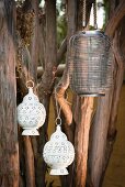 Ethnic lanterns made from wire and perforated, white metal hanging from branches