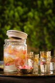 A jar of rose water lemonade and oriental tea glasses on a tray