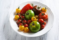 Various different coloured tomatoes on a white plate