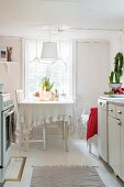 Rustic kitchen with dining set below window and simple pendant lamp with fabric lampshade