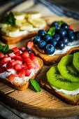 Healthy fruit open sandwiches on a wooden board