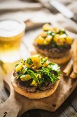 Grilled cheeseburgers with potatoes and beer on a chopping board