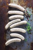 Raw sausages on a metal surface