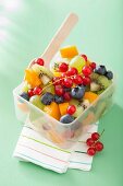 Fruit salad in a lunch box with a fork