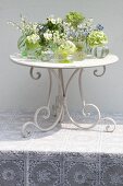 Arrangement of tiny vases of spring flowers on table