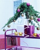 Small conifer in pink pot decorated with baubles