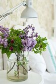 Bouquet of lilac and wild roses in simple glass vase