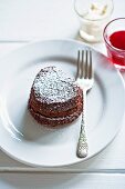 A cake heart with chocolate mousse, raspberry sauce and cream