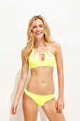 Junge blonde Frau in gelbem Bikini