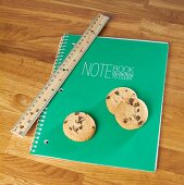 Chocolate chip cookies on a notebook with a ruler