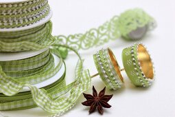Grüne Geschenkbänder und beklebte Kerzenhalter für Adventskranz