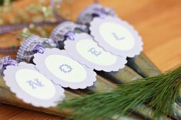 Hanging vases with letters on purple tags reading 'Noel' when put together