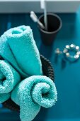 Rolled, turquoise towel in a container