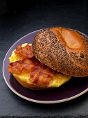 Scrambled egg and bacon on a poppy seed roll for breakfast