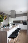 Island counter and bar stool in modern kitchen with concrete-effect walls